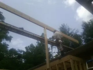 Carpenter setting a ridge beam over a new addition frame — Ice Dam Removal by Roofing Brothers in East Texas