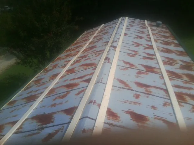 Rusted metal roof panels with new wood purlins before replacement — Storm Damage Roof Repair in East Texas by Roofing Brothers