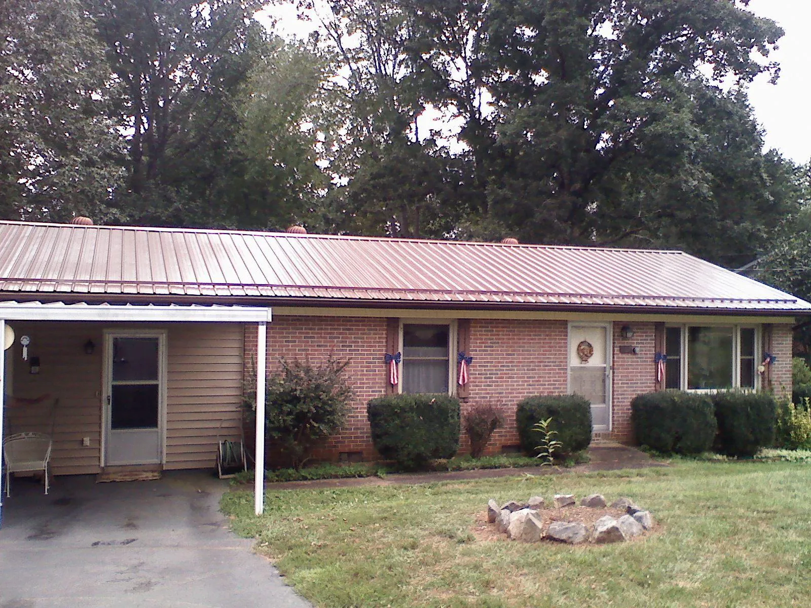 Bronze metal roof and carport on a brick ranch home — Roof Repair work by our crew in East Texas
